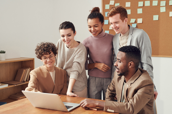 A group of people gathered around a laptop