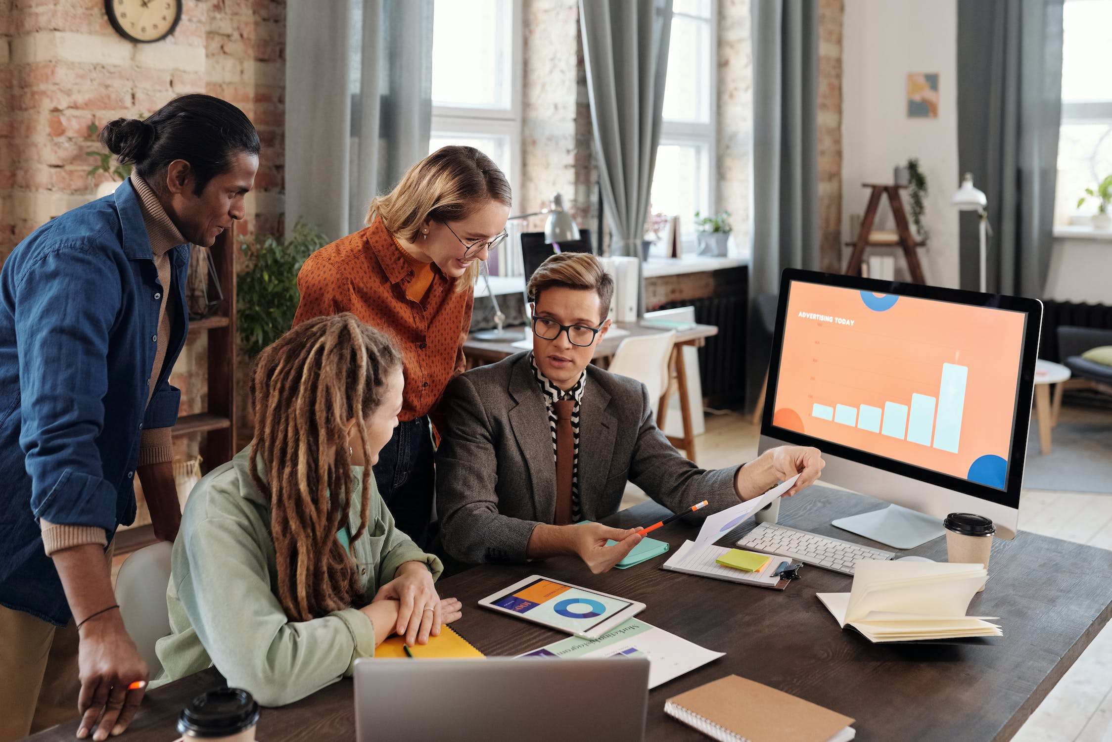 People gathered around a desk looking at a report