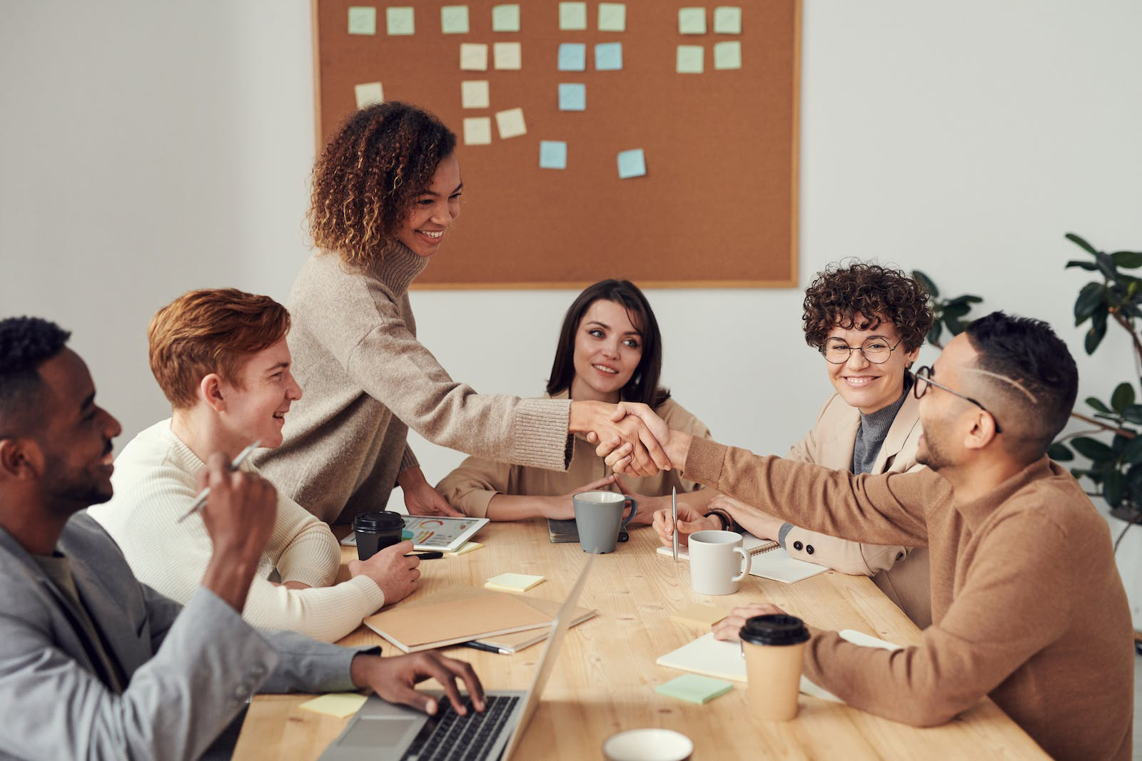 Two people shaking hands across a table