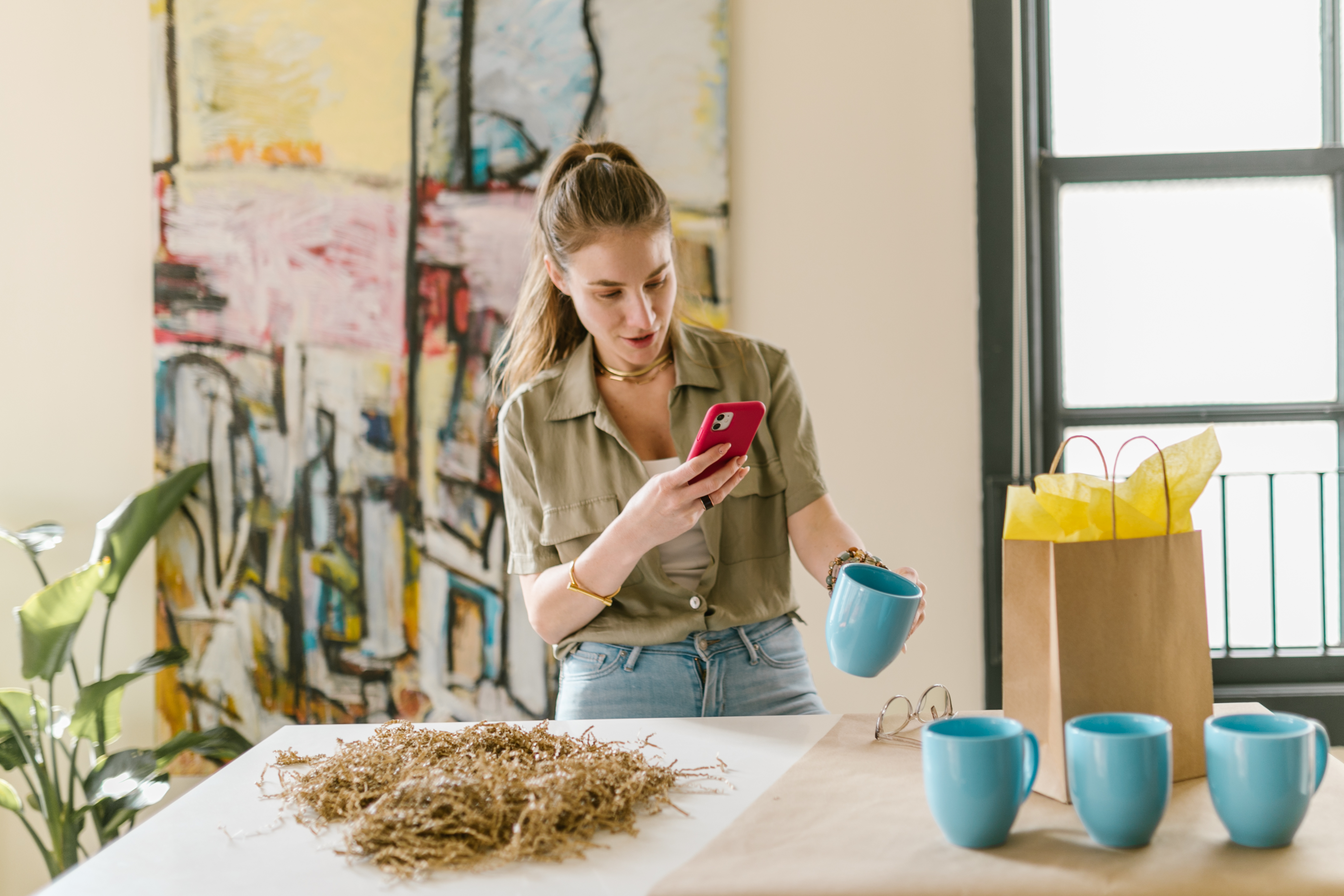 Woman taking photo of blue mugs