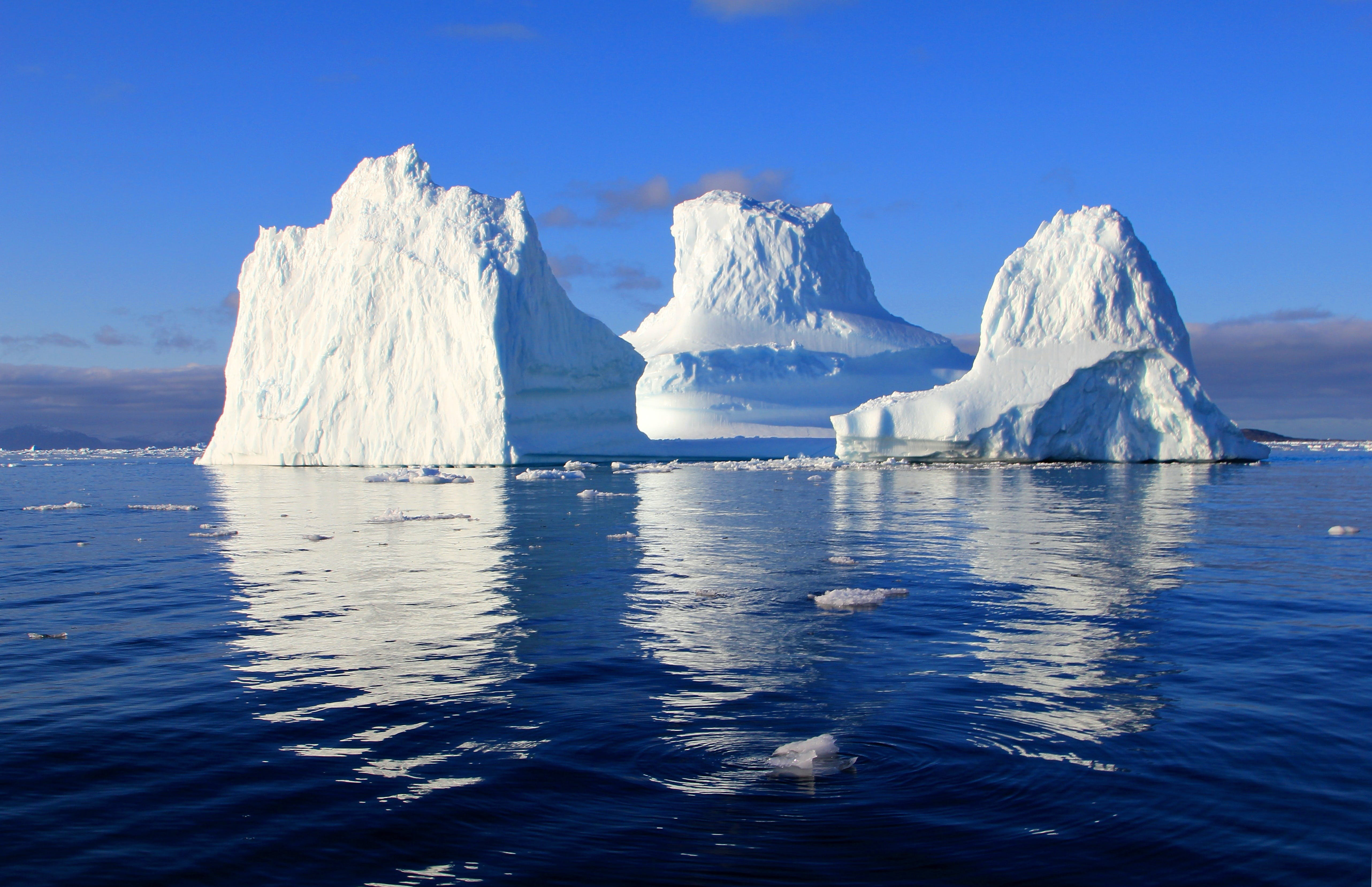Three icebergs in middle of the ocean