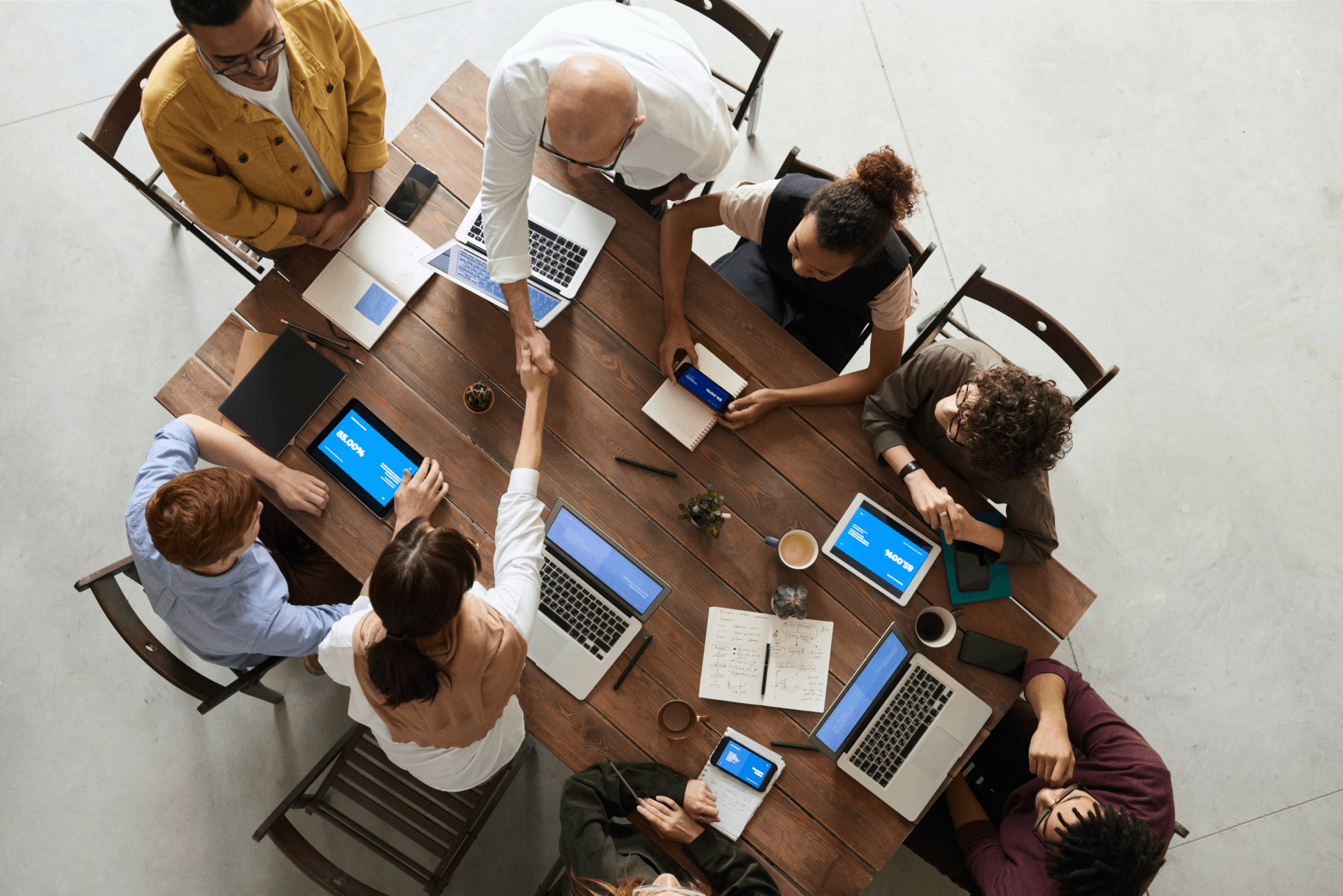 People sitting around a table and shaking hands